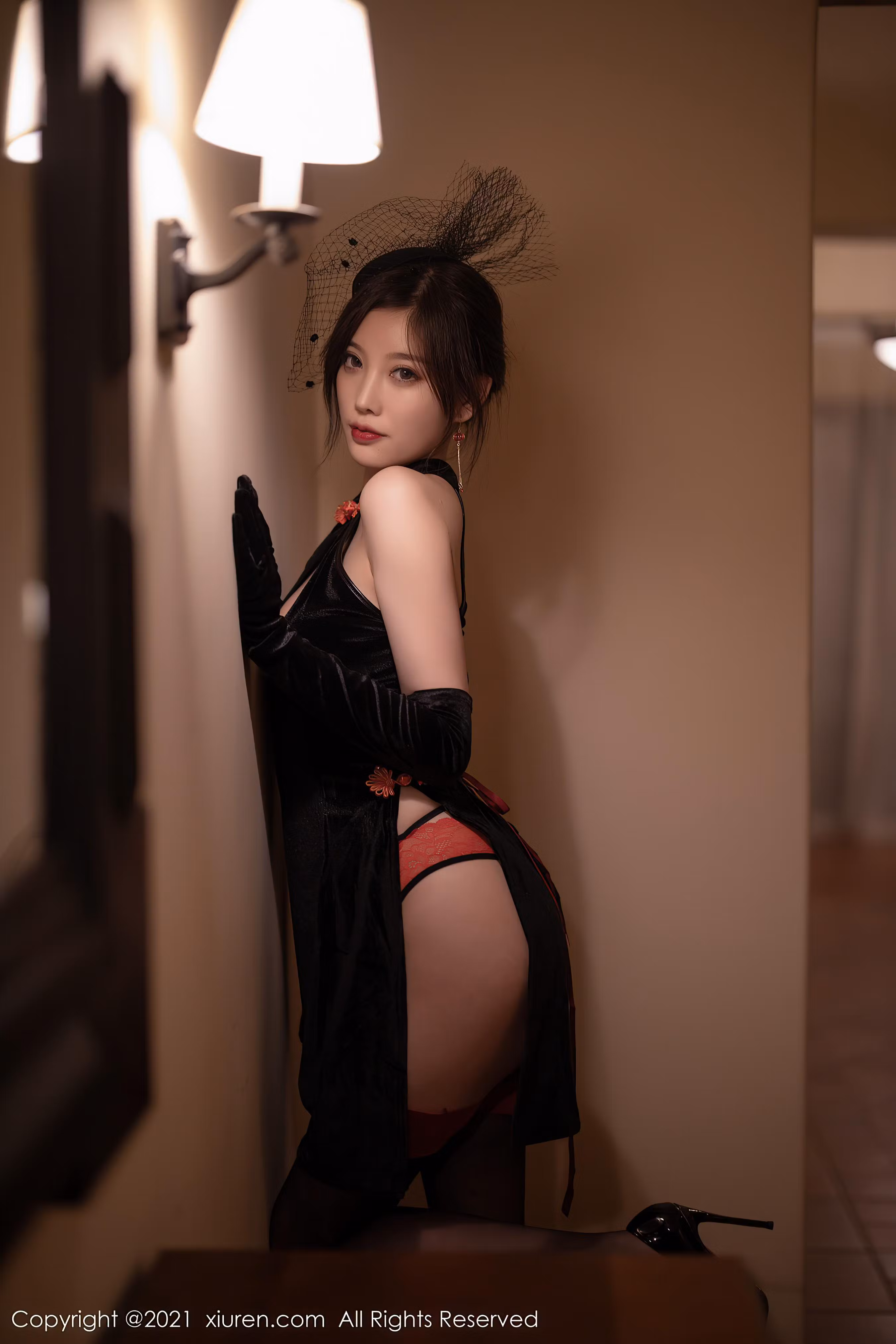 手中拿黑色折扇侧身面对木质镜框镜子